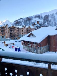 un complexe dans la neige avec des toits recouverts de neige dans l'établissement Le Sappey-Pied des pistes-Parking gratuit, à Les Deux Alpes