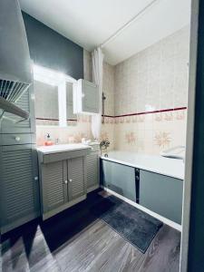 une salle de bains avec baignoire et lavabo dans l'établissement Le Sappey-Pied des pistes-Parking gratuit, à Les Deux Alpes