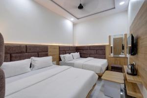 Postel nebo postele na pokoji v ubytování Hotel Apple View,Ahmedabad