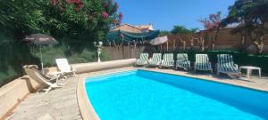 a group of chairs and a swimming pool at Maison Villa d'exception meublée piscine privée & cheminée a 2min plage et commerces in Marseillan
