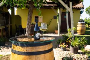 a bottle of wine and two glasses on a barrel at Casa VIDA in Neštin