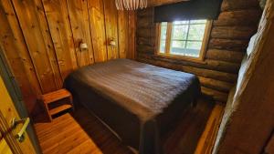 a bedroom in a log cabin with a bed at Lomaruka in Ruka