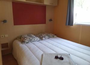 ein großes Bett in einer Ecke eines Zimmers in der Unterkunft Mobilhome 5 place proche mer in Angles