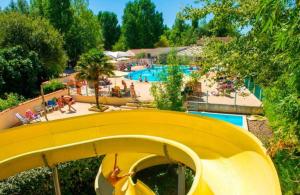 eine gelbe Rutsche in einem Resort mit Pool in der Unterkunft Mobilhome 5 place proche mer in Angles