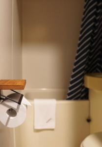 a bathroom with a toilet paper dispenser and a staircase at Hotel Wohnen in Hakuba