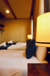a hotel room with two beds and a lamp at Hotel Wohnen in Hakuba