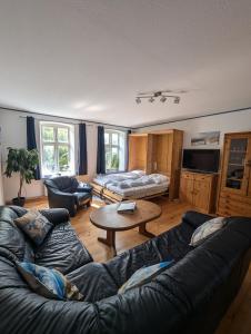 a living room with a couch and a table at Landhaus Oldorf in Rodenäs