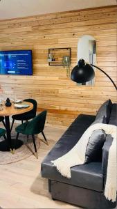 a living room with a black couch and a table at Casa Twins - Slanic Moldova in Slănic-Moldova