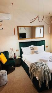 a bedroom with a large bed and a chair at Casa Twins - Slanic Moldova in Slănic-Moldova