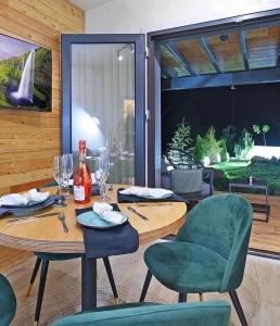 a dining room with a table and chairs with wine glasses at Casa Twins - Slanic Moldova in Slănic-Moldova