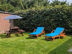 two chairs and a picnic table and an umbrella at Landhaus Oldorf in Rodenäs