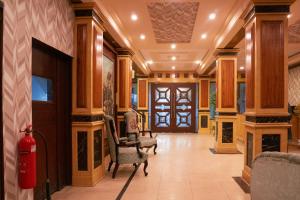 a lobby with chairs and a fire extinguisher at Hotel Mayfair in Lahore
