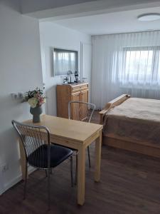 a bedroom with a table and chairs and a bed at Grünes Studio in Hameln +8 photos