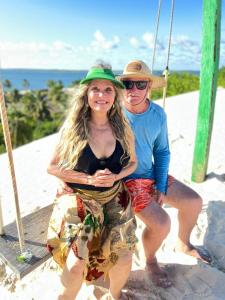 Ein Mann und eine Frau sitzen auf einer Schaukel in der Unterkunft Sr & Sra White in Praia Da Caueira + 2 Fotos