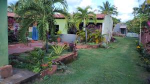 ein Haus mit Palmen im Hof in der Unterkunft Sr & Sra White in Praia Da Caueira