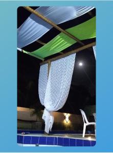 ein Zelt und ein Stuhl auf einer Terrasse bei Nacht in der Unterkunft Sr & Sra White in Praia Da Caueira