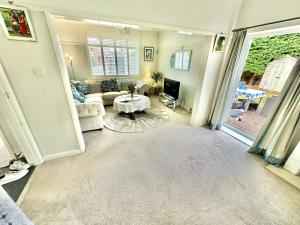 a living room with a couch and a table at Three Bed Detached Home - Large Garden - Hot Tub - Free Parking - Close to Beach! in Iford