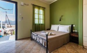 a bedroom with a bed and a large window at Firiki Studios in Zefiría +30 photos