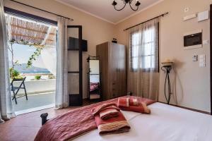 a bedroom with a large bed and a large window at Firiki Studios in Zefiría