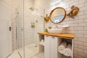 a bathroom with a sink and a shower at The Cape Aquanaut Luxury Seaview Apartment in Cape Town