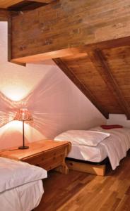 ein Schlafzimmer mit 2 Betten und einem Tisch mit einer Lampe in der Unterkunft Meublè Lo Miete Viei in Champoluc