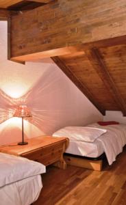 a bedroom with two beds and a table with a lamp at Meublè Lo Miete Viei in Champoluc