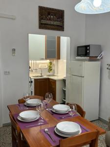 Una mesa de comedor con platos y copas de vino. en Vivi Aguilera apartament, en Bolonia 15 fotos más
