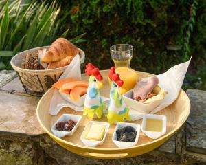 a plate of food with cheese and a glass of orange juice at Les HerbesFolles de Oizy in Oizy
