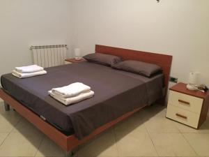 Un dormitorio con una cama grande con toallas. en Jolie villa avec piscine privée, en Porto Empedocle