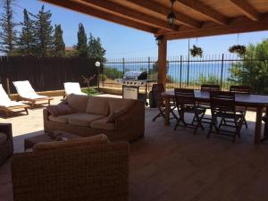 un patio con sofá, mesa y sillas en Jolie villa avec piscine privée, en Porto Empedocle