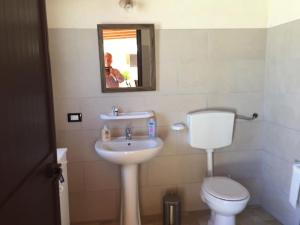 Un baño con lavabo, inodoro y espejo. en Jolie villa avec piscine privée, en Porto Empedocle 12 fotos más
