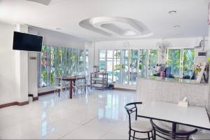 a large room with tables and chairs and windows at Srivara Place โรงแรมศรีวรา เพลส in Phetchabun