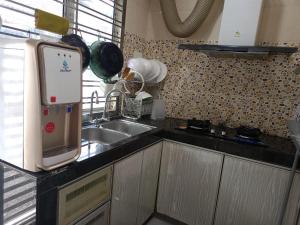 a kitchen with a sink and a microwave at Umieta Homestay in Johor Bahru