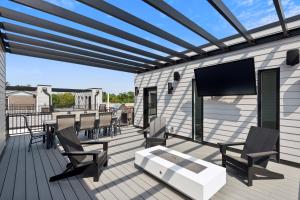 アイオワシティにあるNew Modern Townhome with Rooftop Patio townhouseの建物の上に椅子とテレビのあるデッキ +20枚の写真