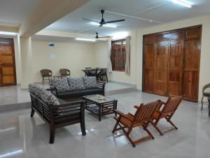 a living room with a couch and chairs and a table at Shilpi Agro Tourism Center in Pendur