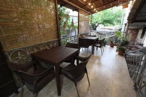 Un patio con mesas y sillas en un balcón. en Riverside Hotel, en Ereván