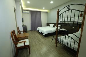 Un dormitorio con dos literas y una silla. en Riverside Hotel, en Ereván