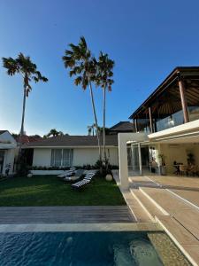 una casa con piscina y palmeras en VILLA CELAVI 15, en Kerobokan 45 fotos más