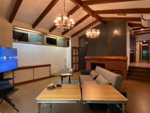 a living room with a couch and a tv at 高原エール#サウナ #海に近い #温泉 #遊具 #雨でもバーベキュー #Wi-Fi in Futo +13 photos