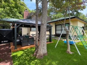 a backyard with a swing and a house at 高原エール#サウナ #海に近い #温泉 #遊具 #雨でもバーベキュー #Wi-Fi in Futo