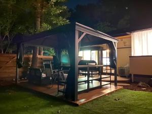 a gazebo with a table in a yard at night at 高原エール#サウナ #海に近い #温泉 #遊具 #雨でもバーベキュー #Wi-Fi in Futo