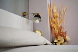 a bed with a lamp and a vase with flowers at CasArancio 6 in San Paolo Albanese
