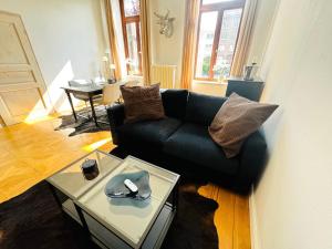 ブレーメンにあるSuperHosts ZENTRUM - Parkplatz - BADEWANNE - Netflix - KAFFEEの黒いソファとテーブルのあるリビングルーム