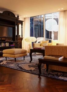 a living room with couches and a tv at Andaz Amsterdam, Prinsengracht, By Hyatt in Amsterdam
