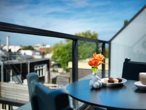 a table with a plate of food and flowers on a balcony at Andaz Amsterdam, Prinsengracht, By Hyatt in Amsterdam