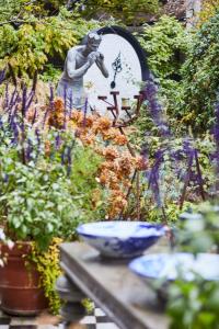 a garden with a statue and a bowl on a table at Andaz Amsterdam, Prinsengracht, By Hyatt in Amsterdam