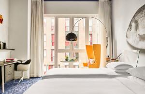 a bedroom with two beds and a desk and a window at Andaz Amsterdam, Prinsengracht, By Hyatt in Amsterdam