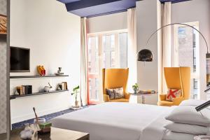 a bedroom with a white bed and a large window at Andaz Amsterdam, Prinsengracht, By Hyatt in Amsterdam