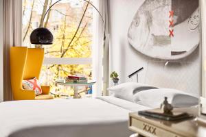 a bedroom with a white bed and a window at Andaz Amsterdam, Prinsengracht, By Hyatt in Amsterdam