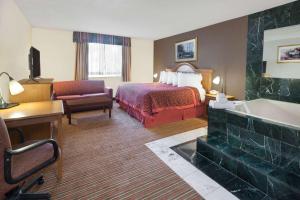 a hotel room with a bed and a bath tub at Days Inn by Wyndham Albion in Albion +33 photos